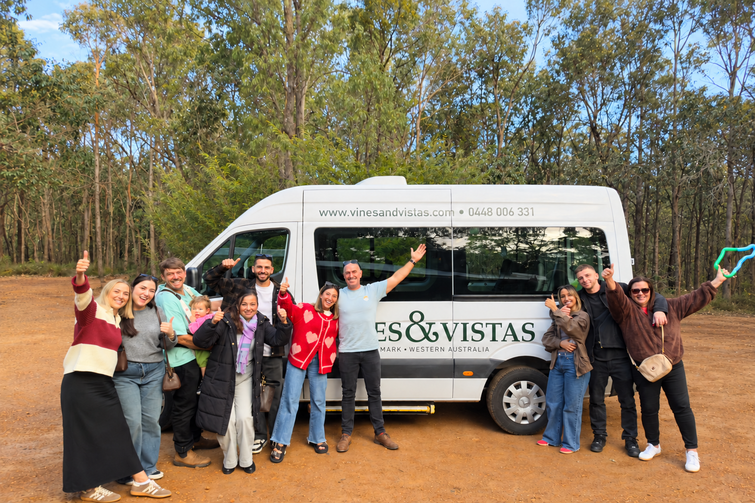 A smiling wine tour group beside the Vines and Vistas van in Denmark